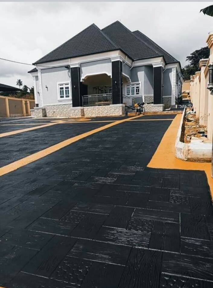 Black stamped concrete driveway with gold borders