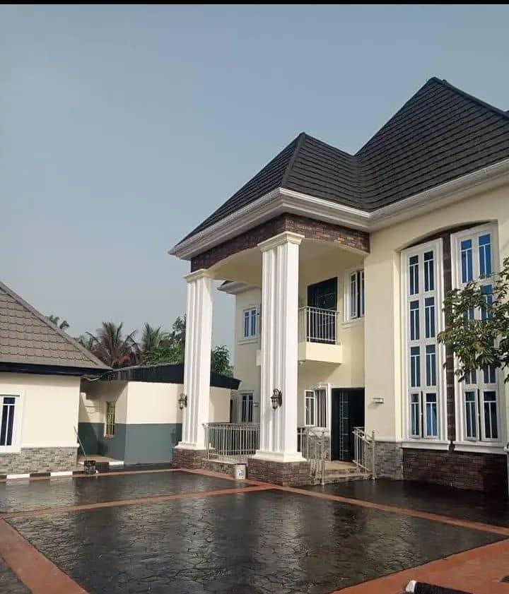 Two storey duplex with stone-coated roof and stamped courtyard
